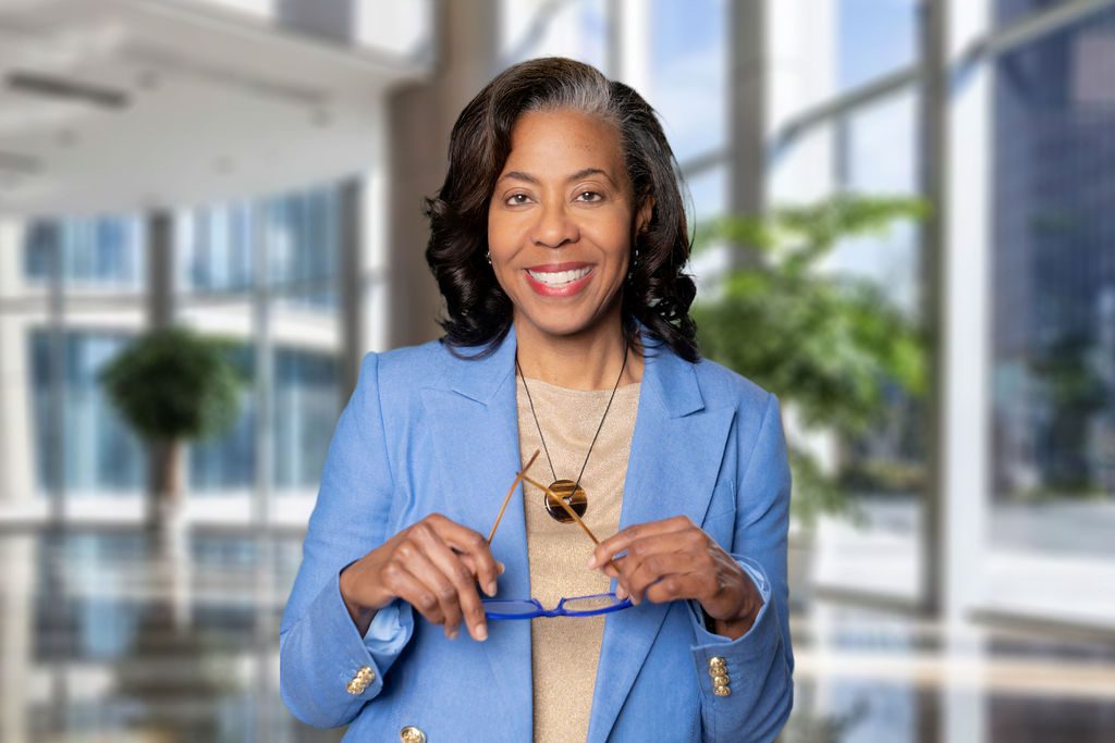 Smiling woman in blue blazer indoors.