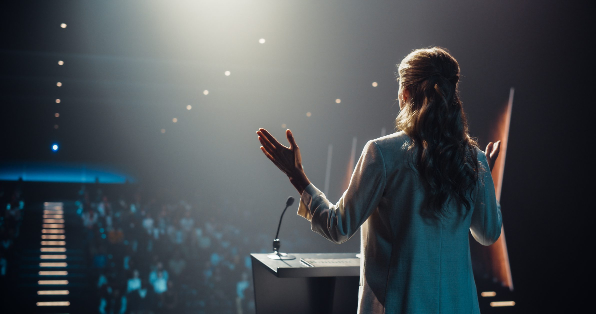 Presenter on stage speaking to audience